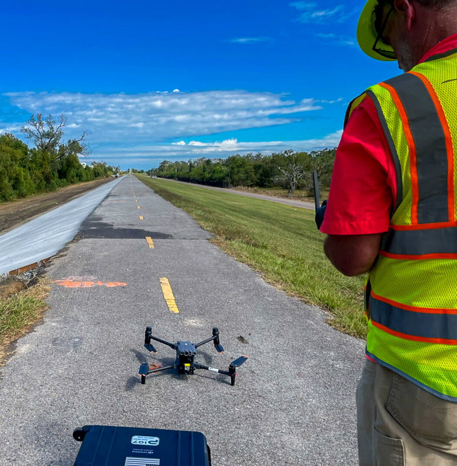 Commercial drone pilot preparing to take off and map a construction project on a Mississippi River Leeve
